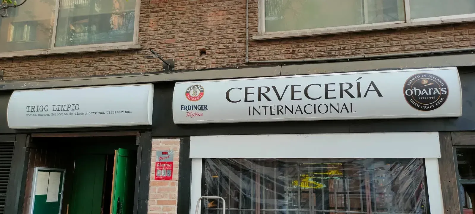 La fachada de Cervecería Internacional, con un letrero blanco, fachada de ladrillo y entrada con paneles de vidrio.