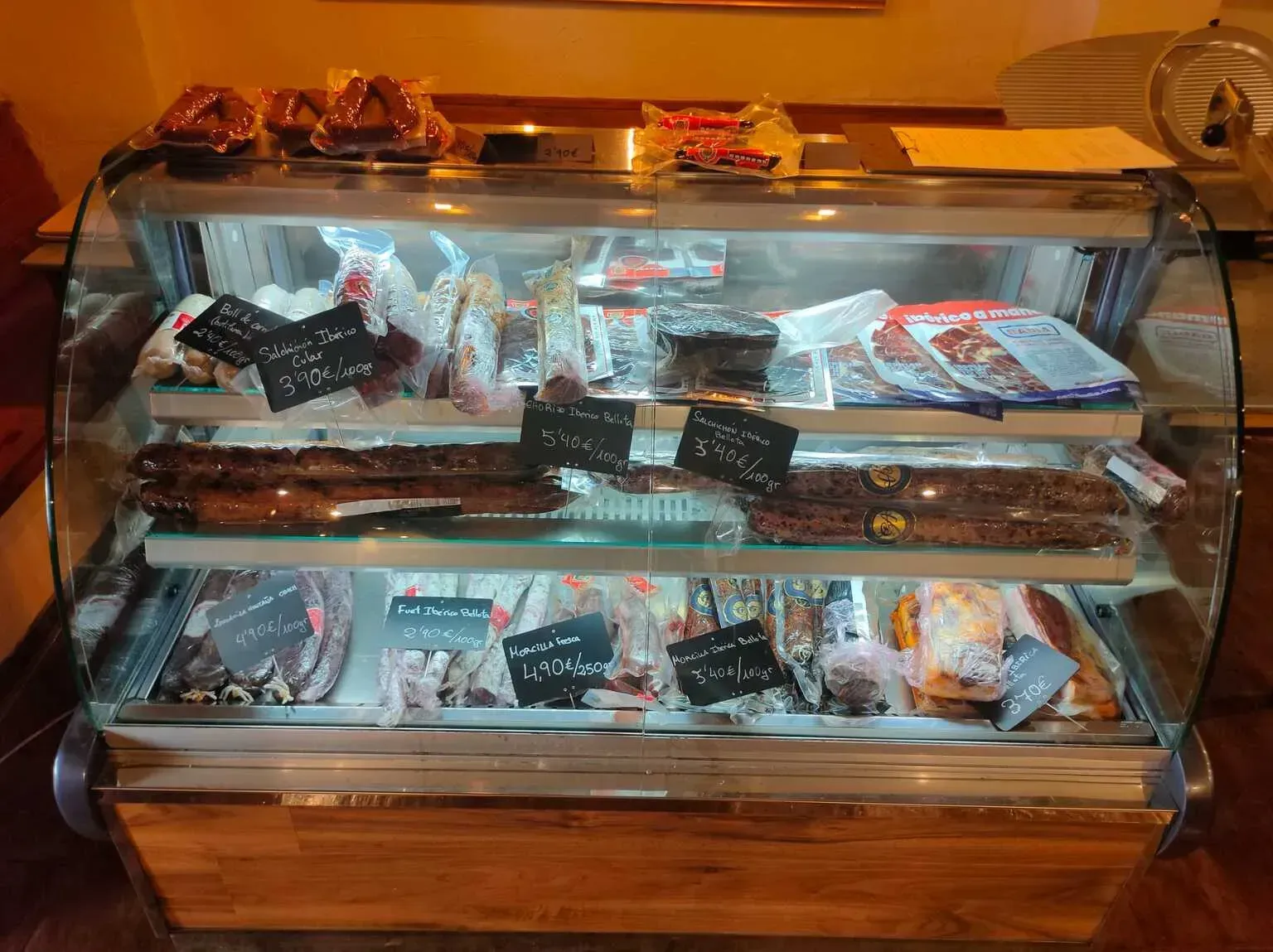 Platos de comida: fiambres, quesos, aperitivos, aceitunas y pan.