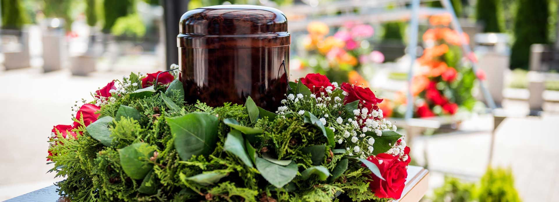 Une urne funéraire entourée d'un couronne de fleurs