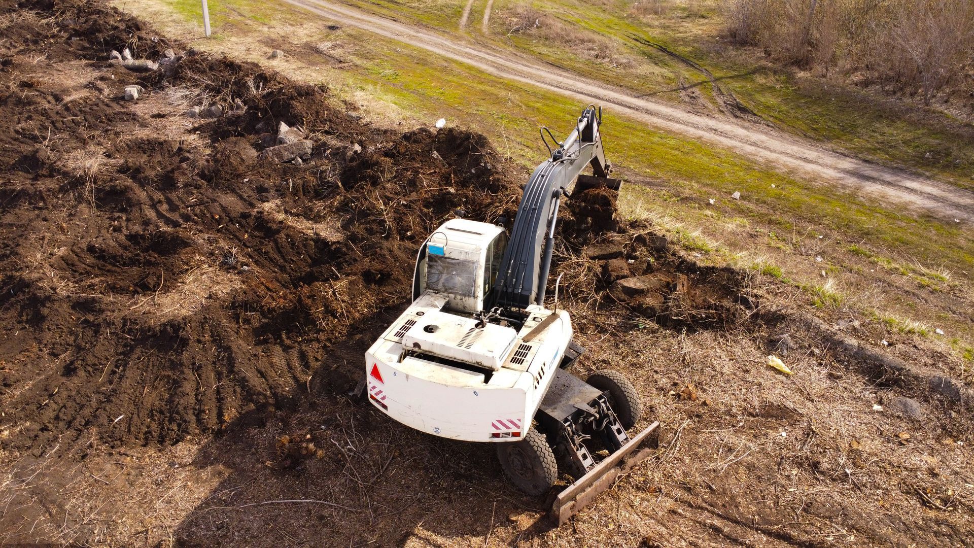 Pelleteuse blanche sur un chantier de construction.