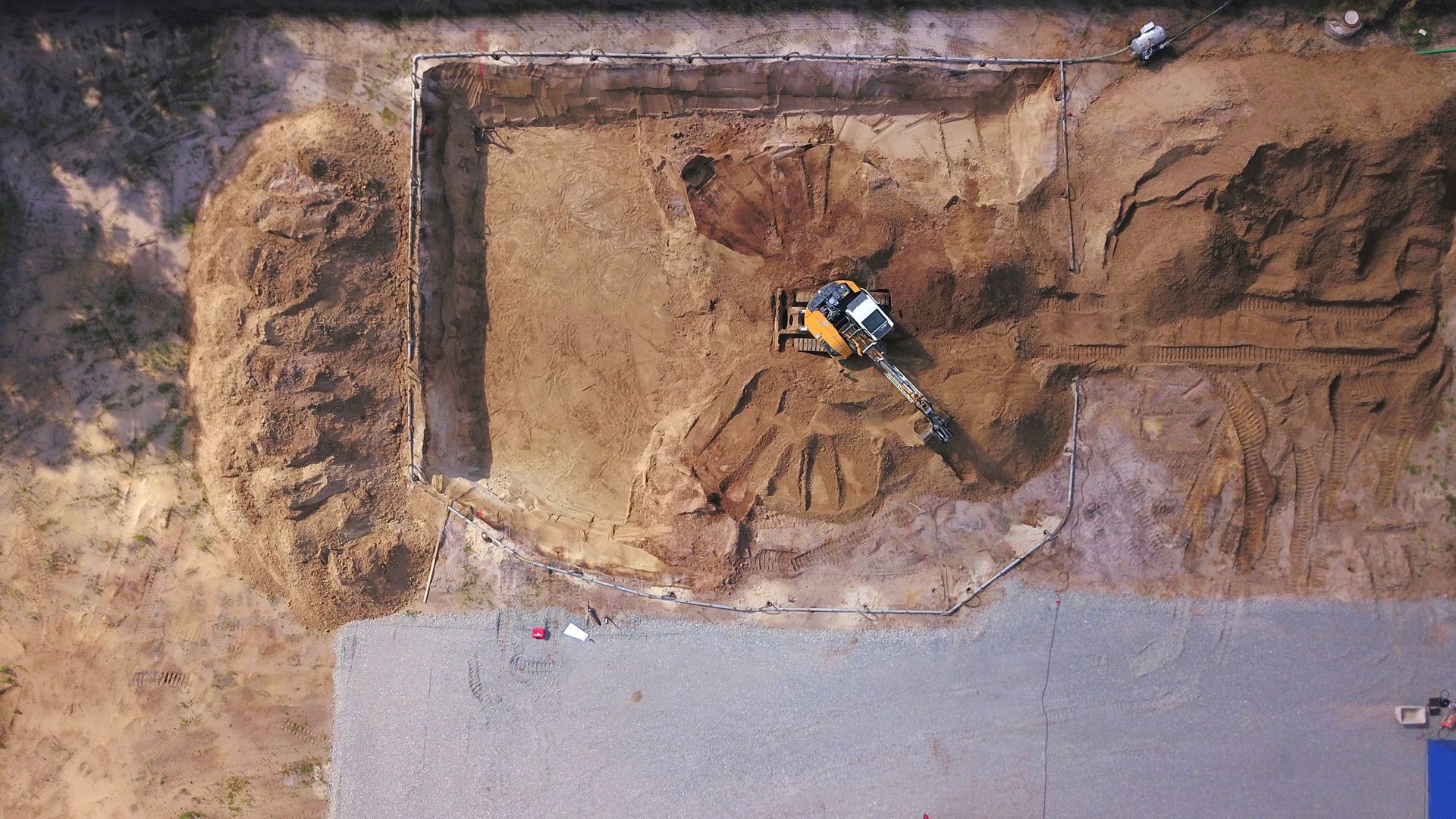 Une excavatrice déblaye la terre sur un chantier de construction.