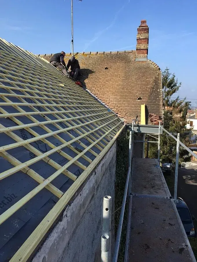 Un toit en cours de pose par deux ouvriers de l'entreprise Toit Service