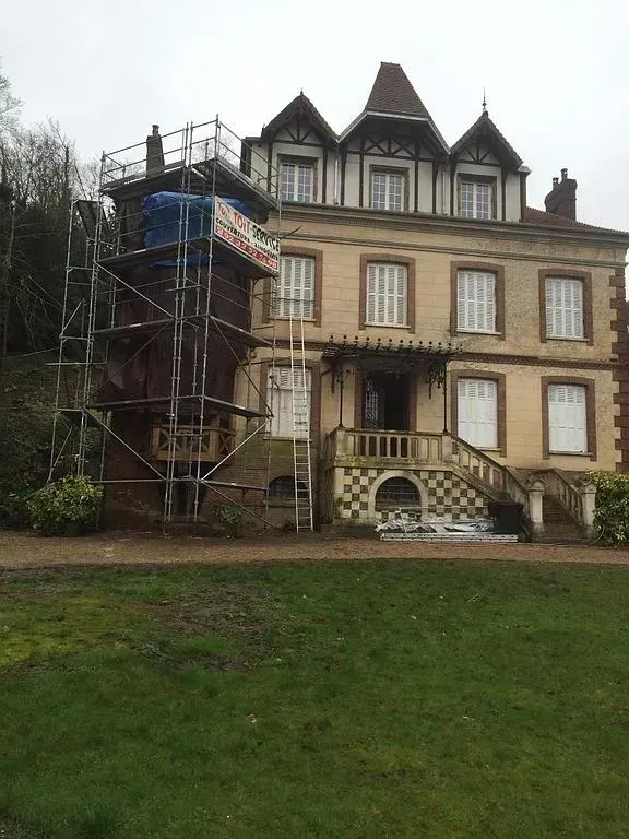 Un échafaudage à côté d'une maison en cours de rénovation de toiture
