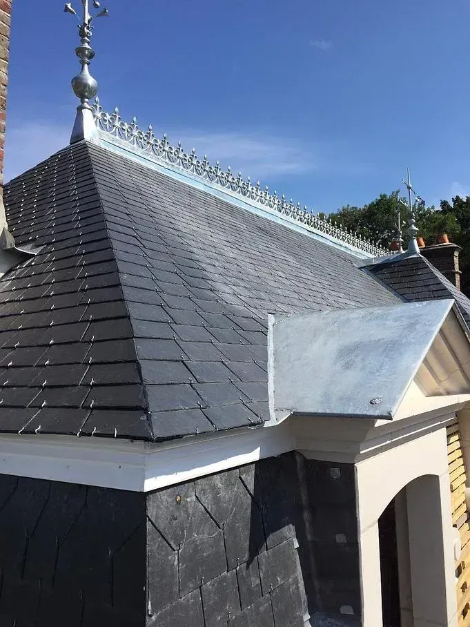 Un toit en ardoises avec un rebord en zinc