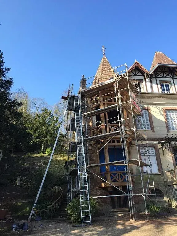 Un échafaudage devant une maison à deux étages en cours de démoussage