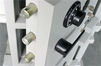 Nahaufnahme eines grauen Banktresors mit Zifferblättern, Schlüsseln und Metallstiftschlössern.