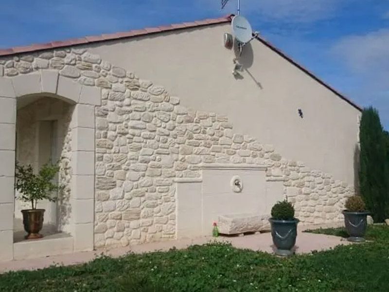 Côté d'une maison avec une partie en pierres apparentes