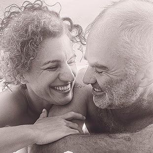 Un hombre y una mujer se sonríen en una fotografía en blanco y negro.