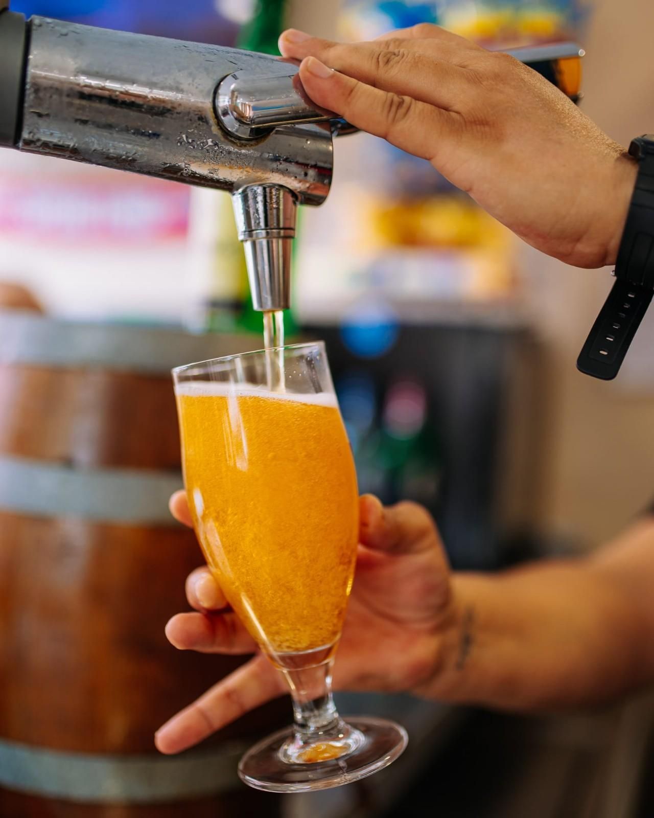 Verter manualmente cerveza de naranja de un grifo en un vaso.