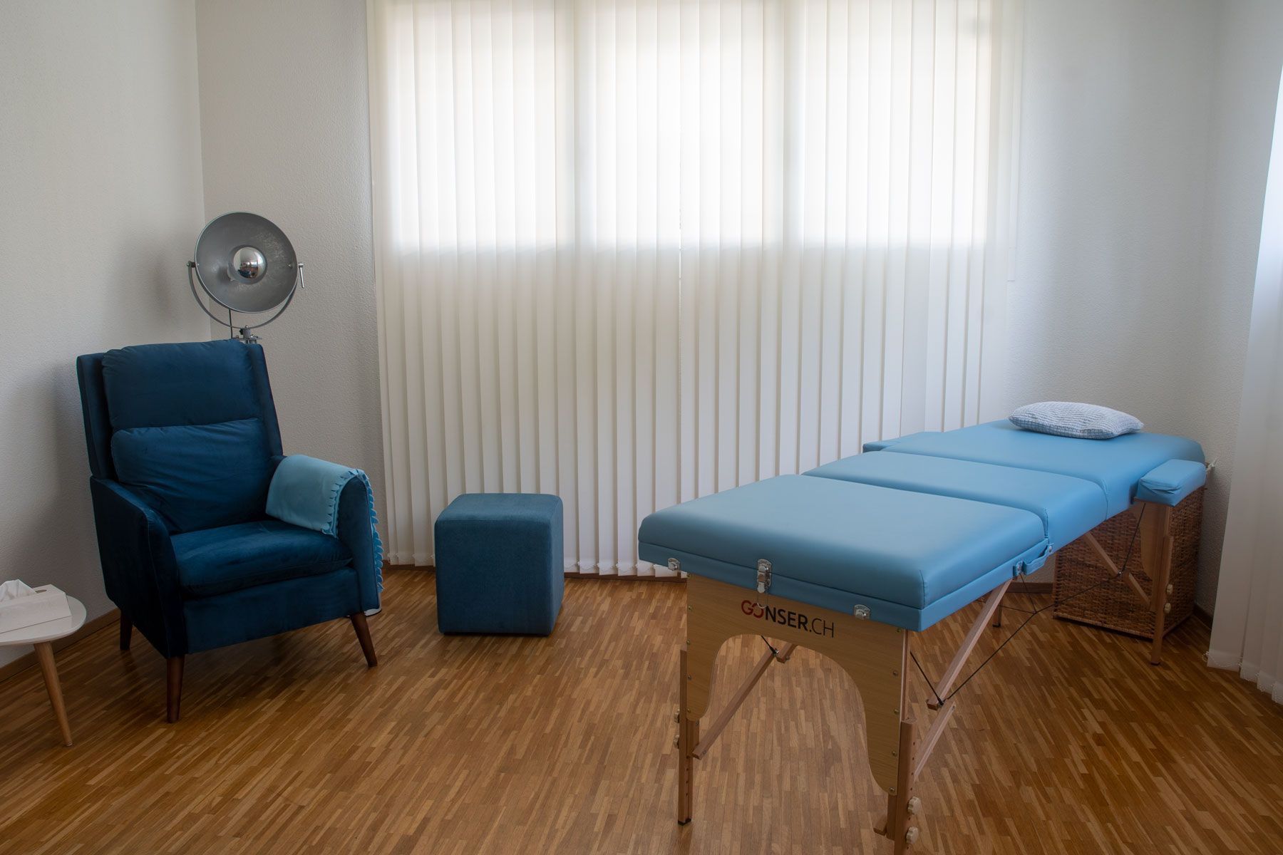 Ein Raum mit einem blauen Stuhl und einem blauen Tisch.