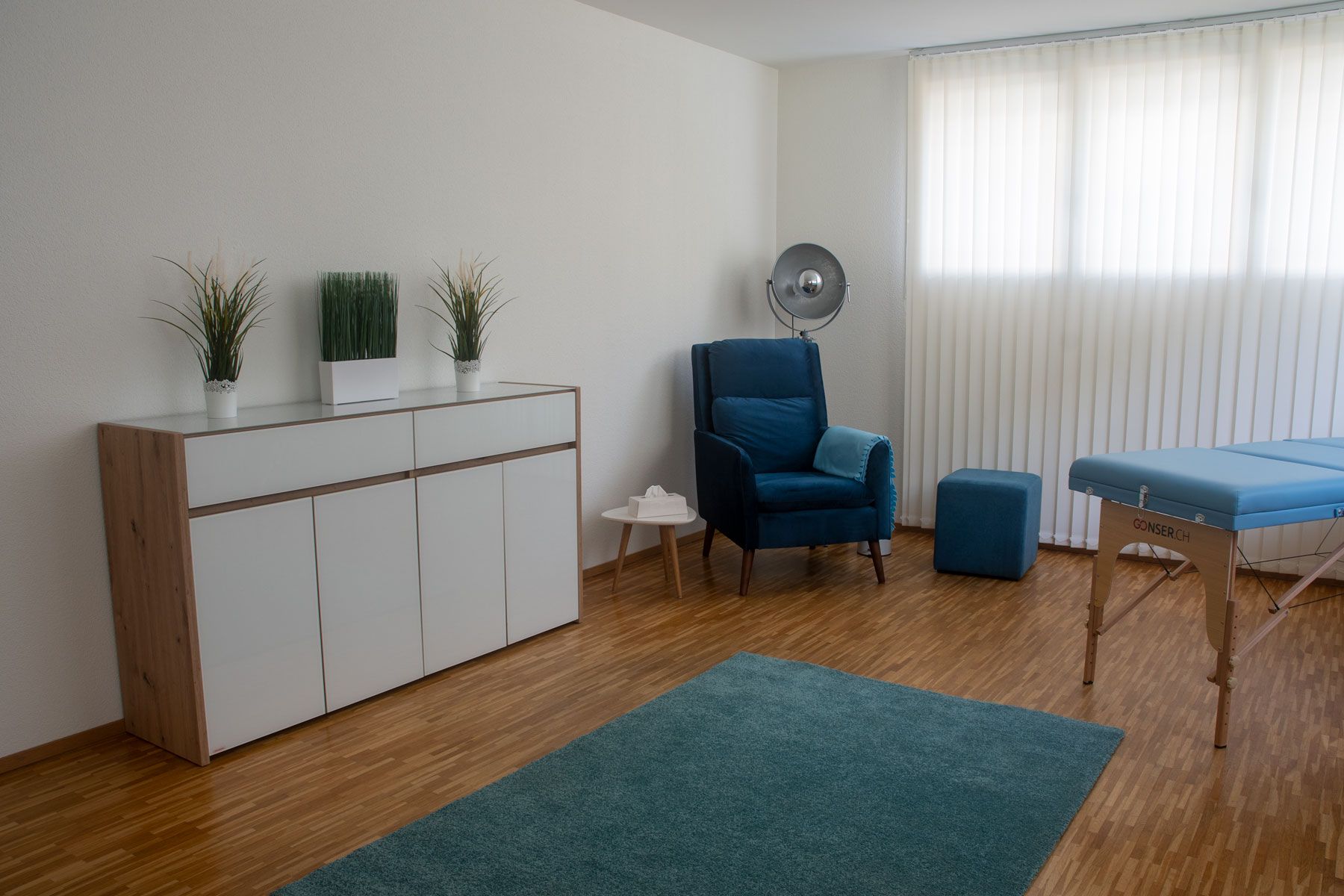 Ein Wohnzimmer mit einem blauen Stuhl und einem blauen Tisch.