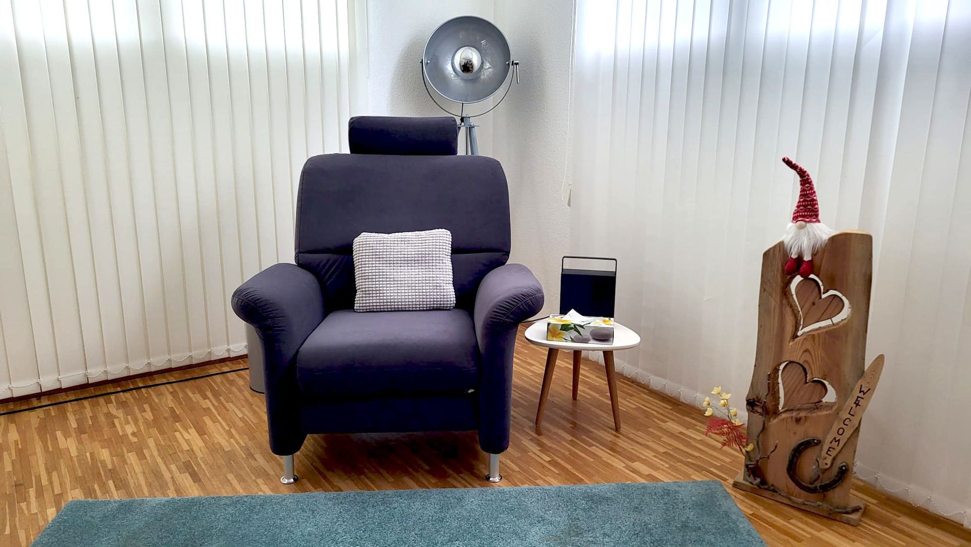 In einem Wohnzimmer steht ein lila Stuhl neben einem Tisch.