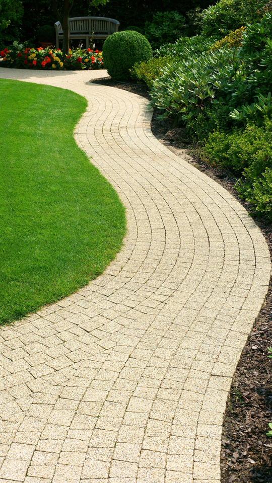 Un jardin après le passage d'un paysagiste avec passage en dalle le traversant