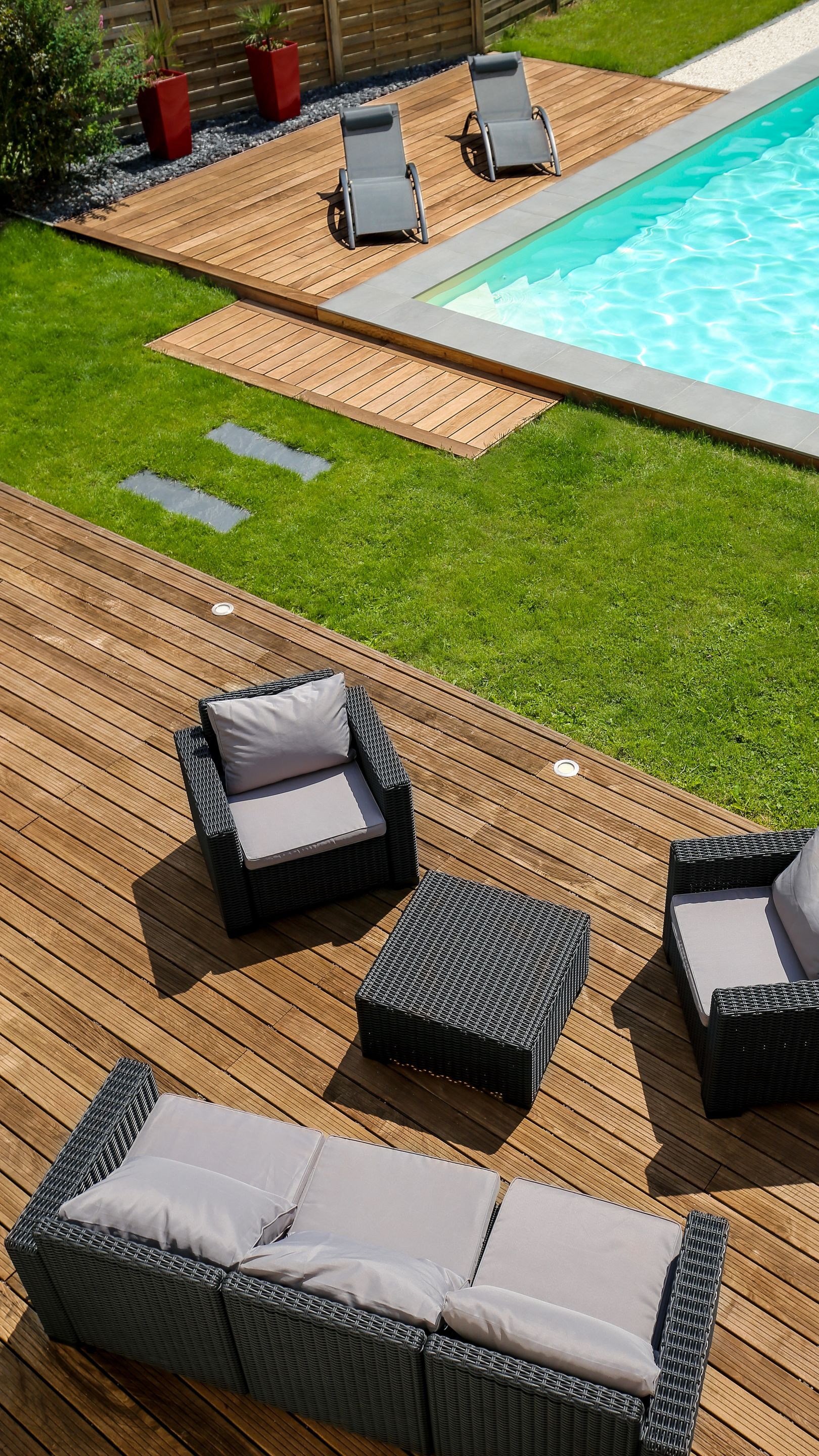 Deux terrasses en bois dont une à côté de la piscine