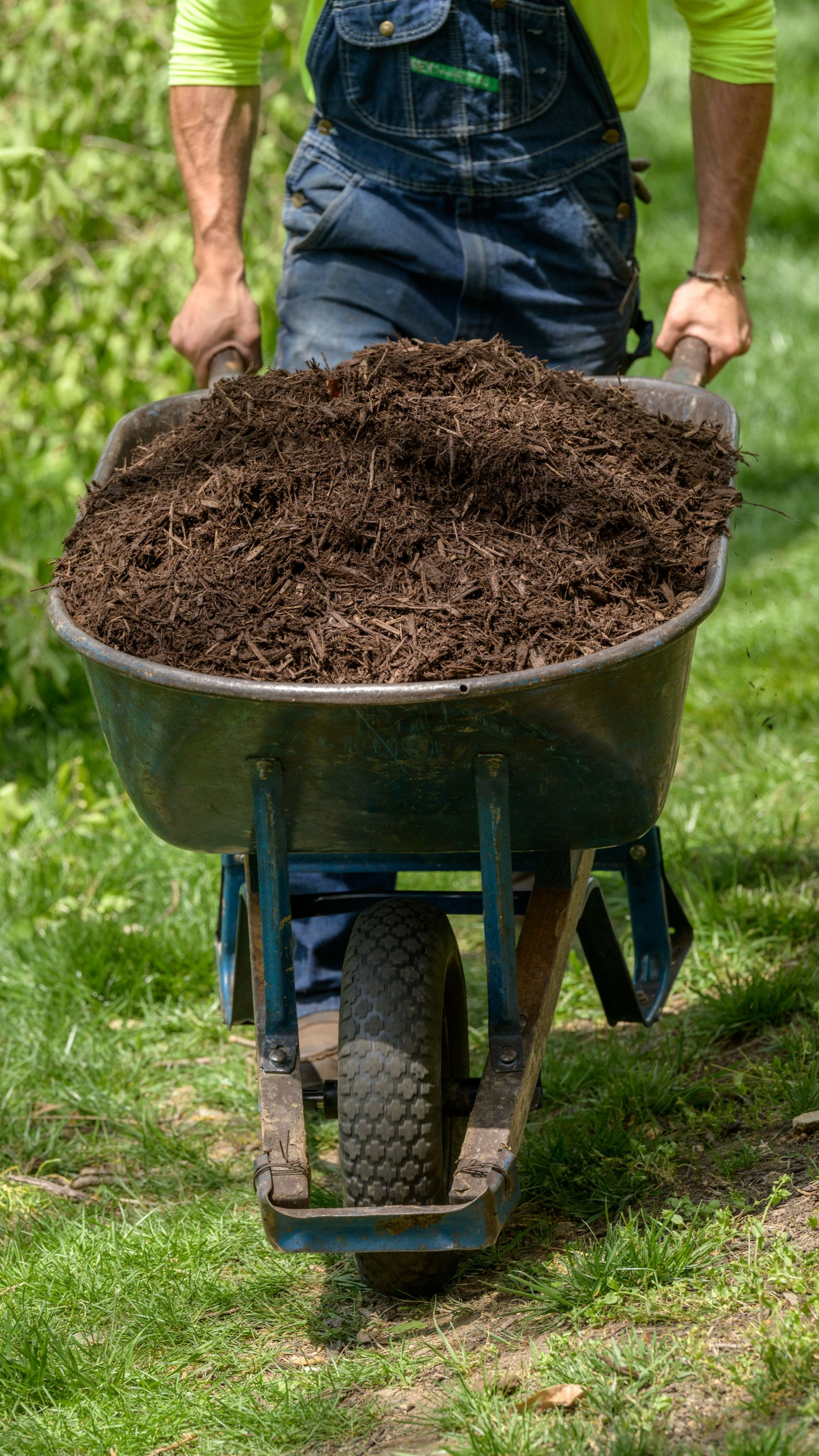 Un jardinier avec sa brouette remplie de terre