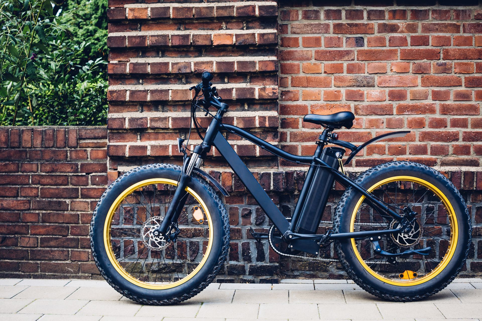 Un vélo adossé à un mur en brique