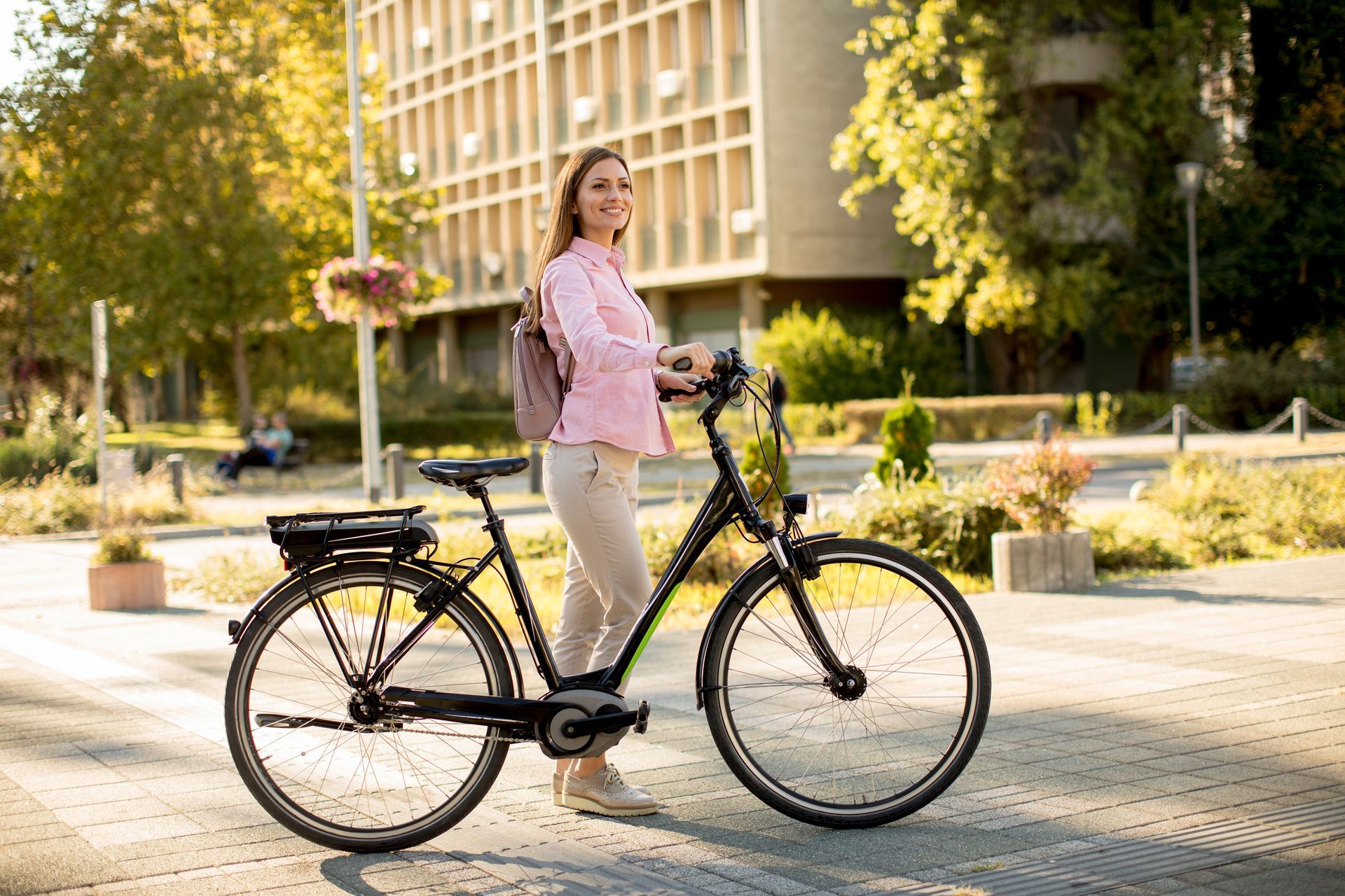 Une femme en chemise rose avec un vélo