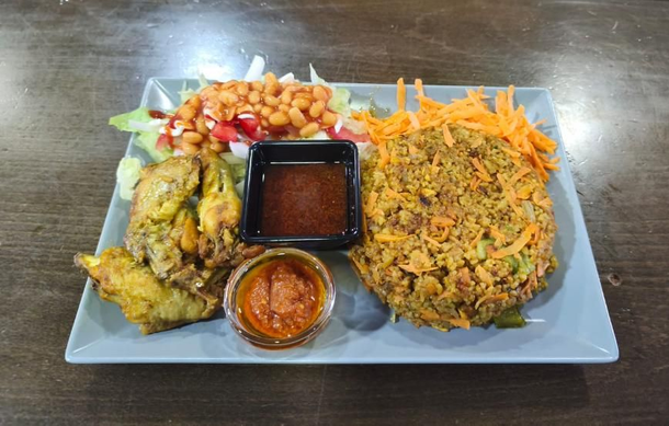 Plato con frituras, frijoles, ensalada, zanahoria rallada y dos salsas.