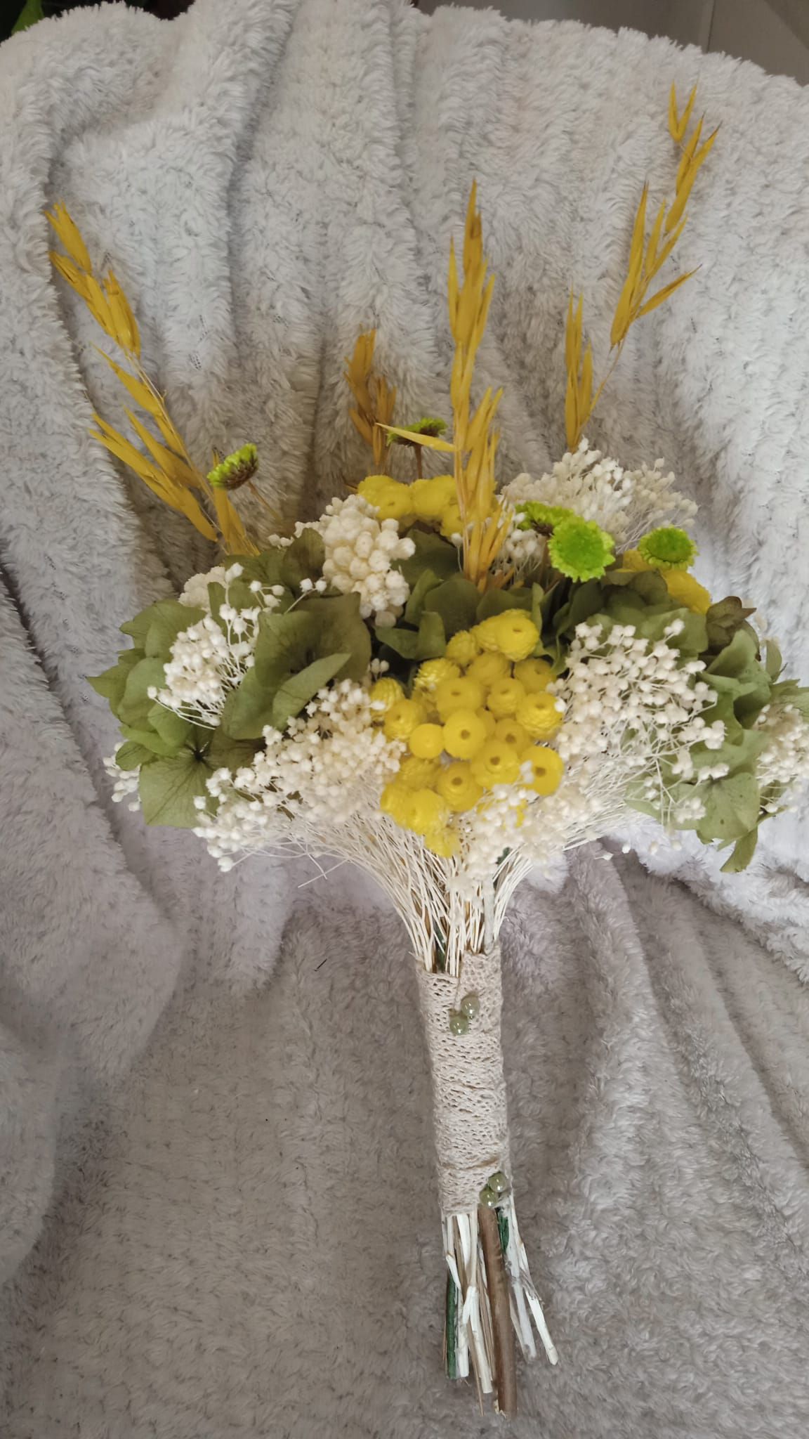 Un ramo de flores reposa sobre una manta blanca.