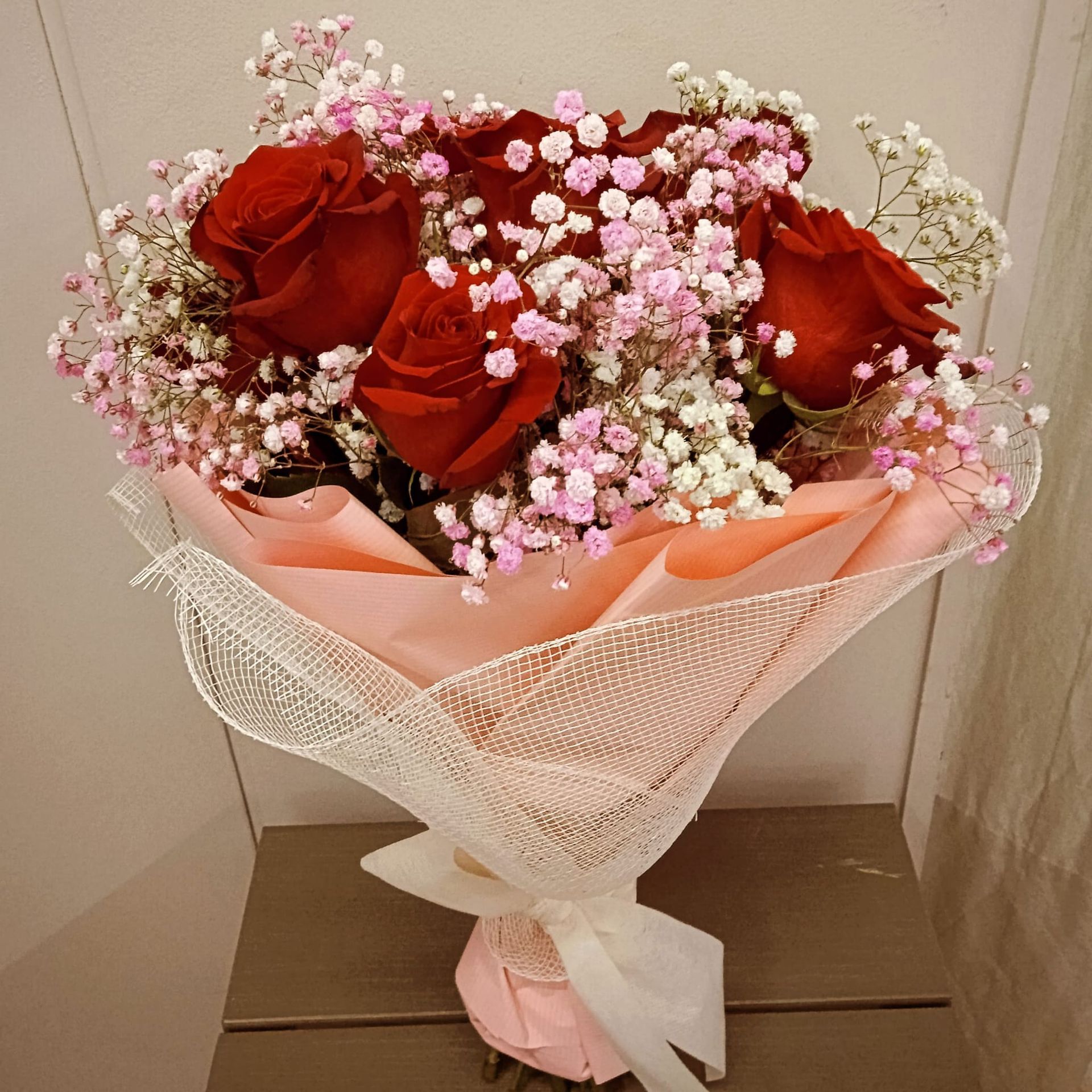 Un ramo de rosas rojas y aliento de bebé rosa