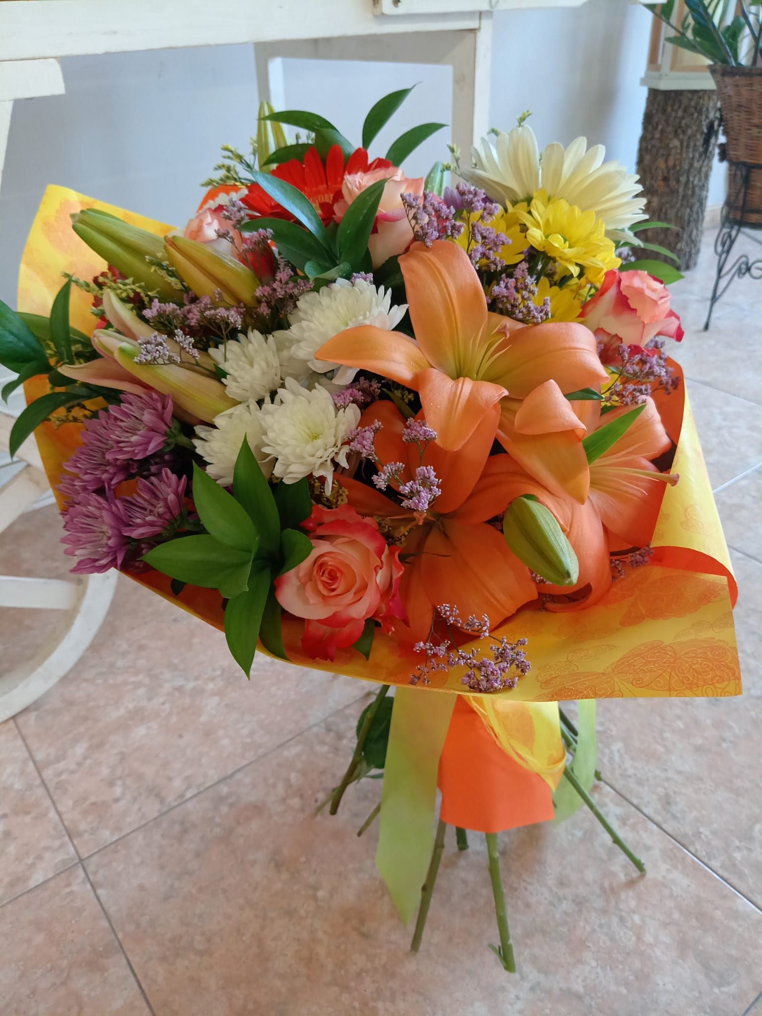 Un ramo de flores está envuelto en papel amarillo.