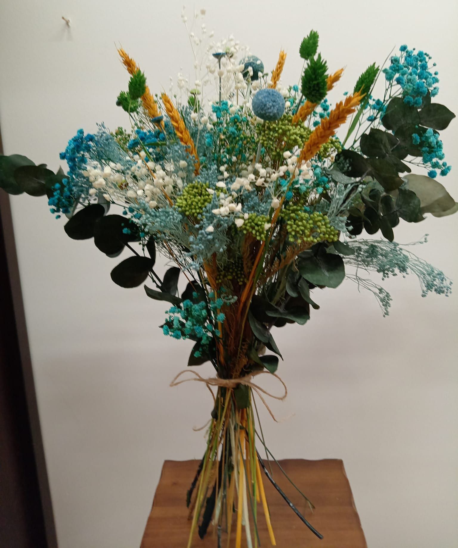 Un ramo de flores está sobre una mesa de madera.