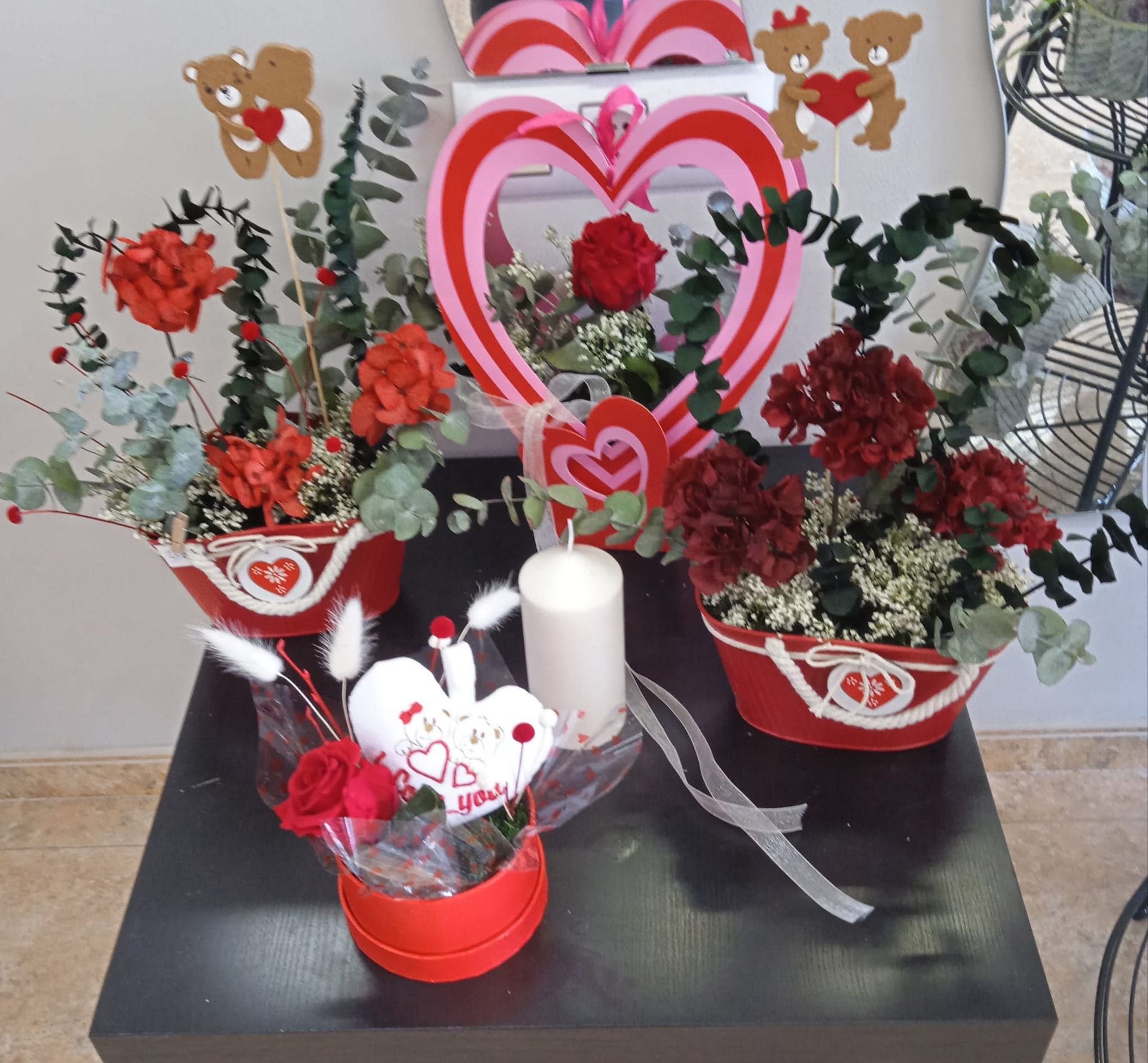 Una mesa con flores y un corazón que dice te amo