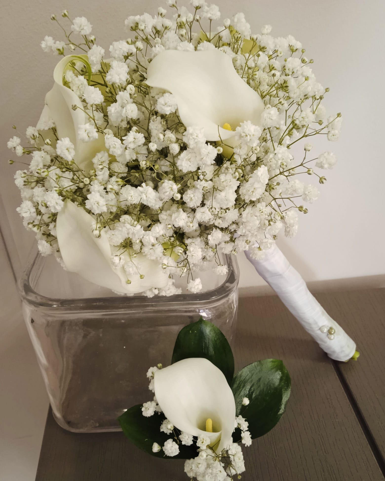 Un jarrón lleno de flores blancas y aliento de bebé.