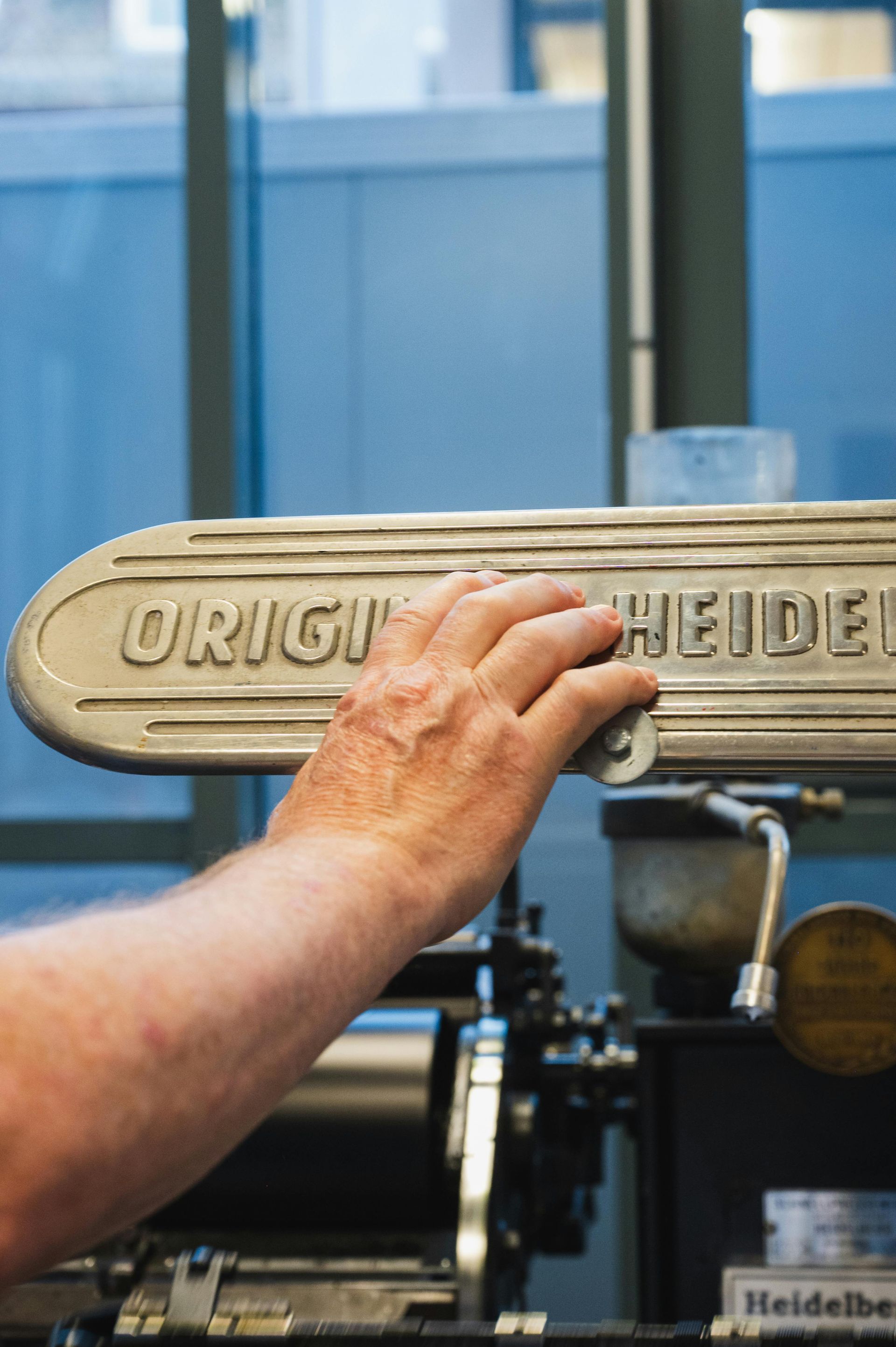 Mano en la placa con el nombre de una imprenta 