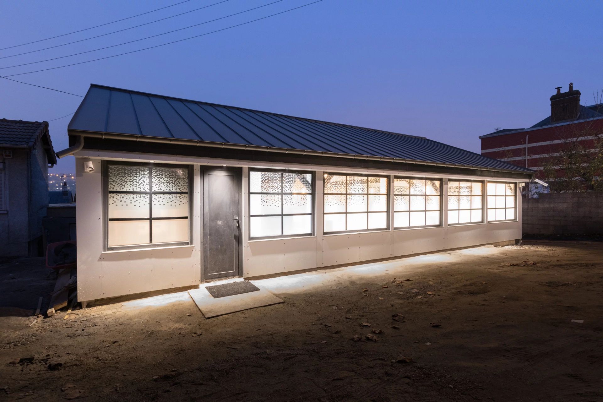 Extérieur d'une habitation éclairée de nuit.