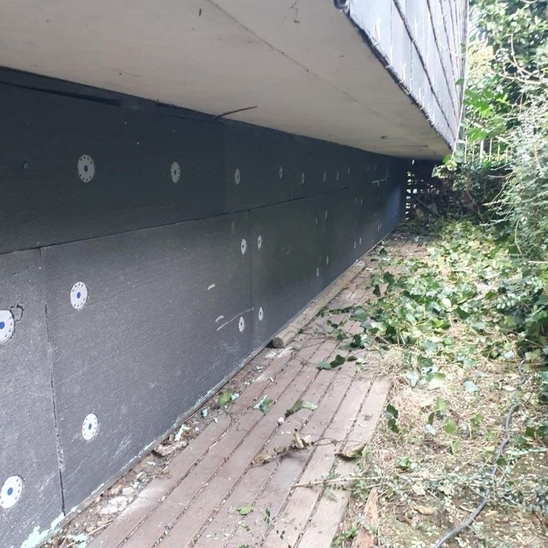 Gros plan de plaques d'isolation extérieur sur la partie basse d'une habitation.