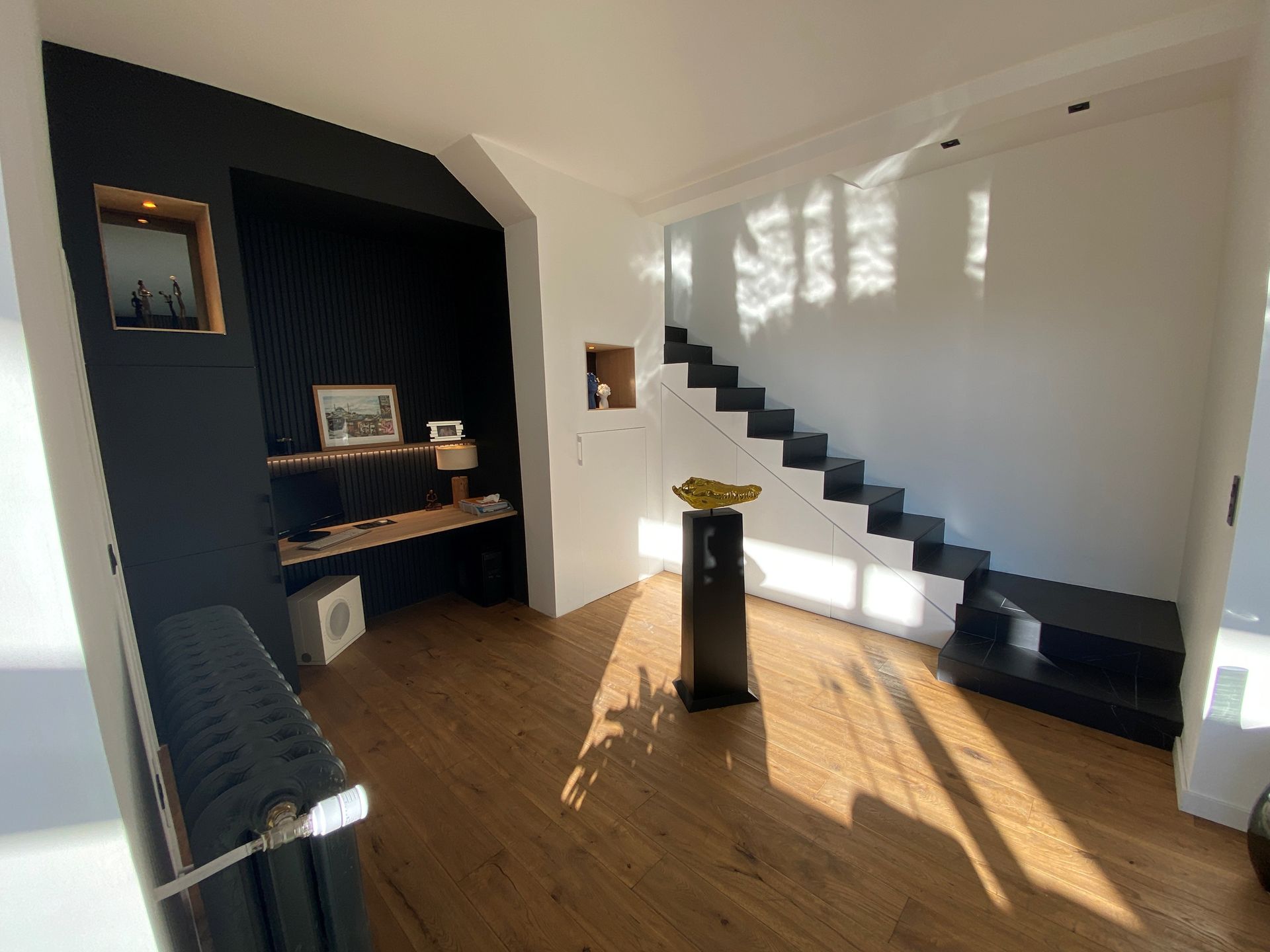 Sous sol aménagé avec accès par un escalier contre le mur.