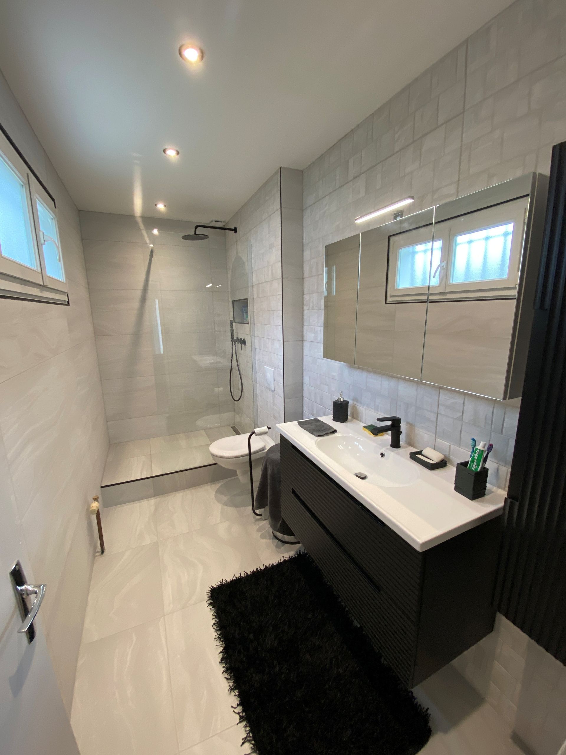 Salle de bains entièrement carrelée.