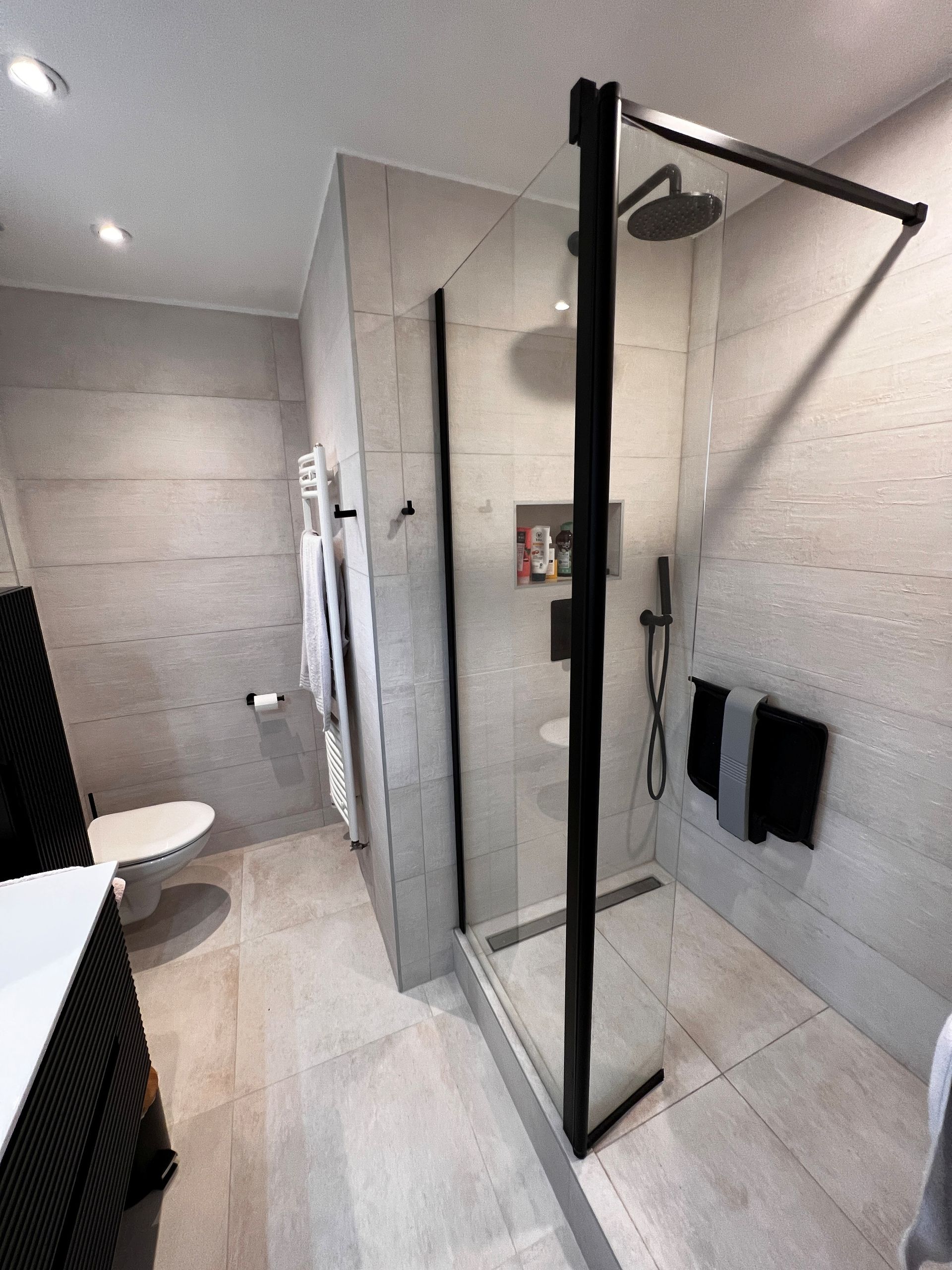 Salle de bains entièrement carrelée avec toilette et cabine de douche 03