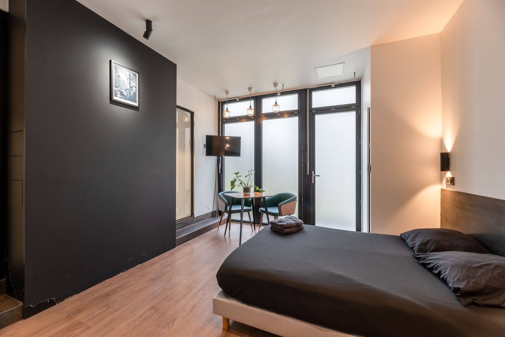 Un lit devant un mur de couleur noir.