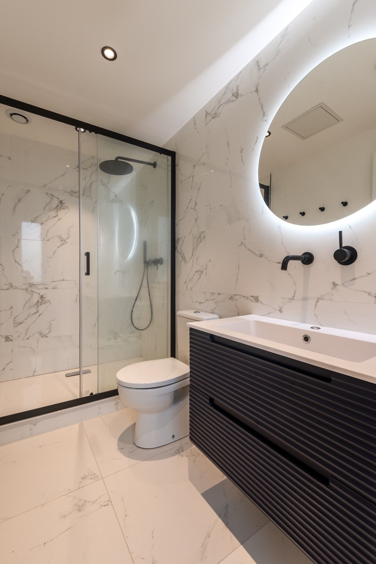 Salle de bains avec douche et vasque.