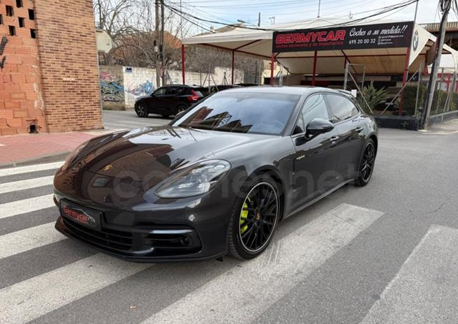 SUV Volkswagen Tiguan negro estacionado en un cruce peatonal frente a un concesionario de automóviles.