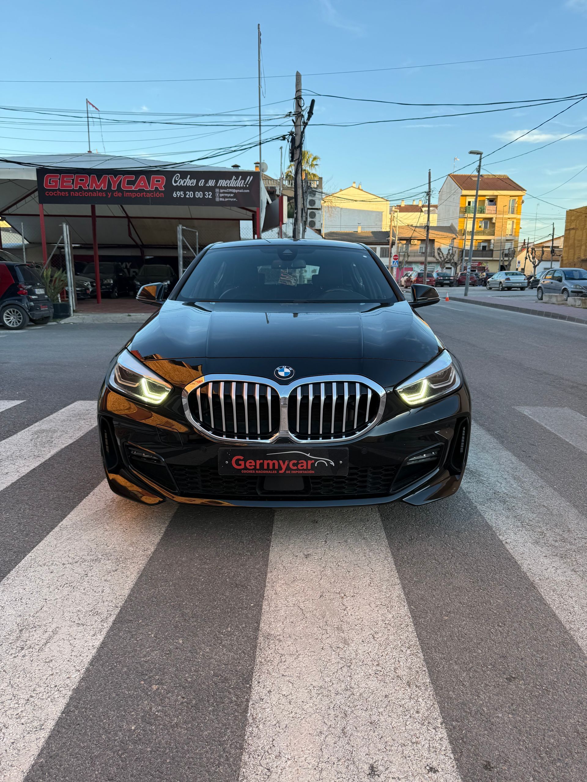 Interior del coche en color negro: salpicadero, volante, asientos, pantalla de infoentretenimiento y alfombrillas.