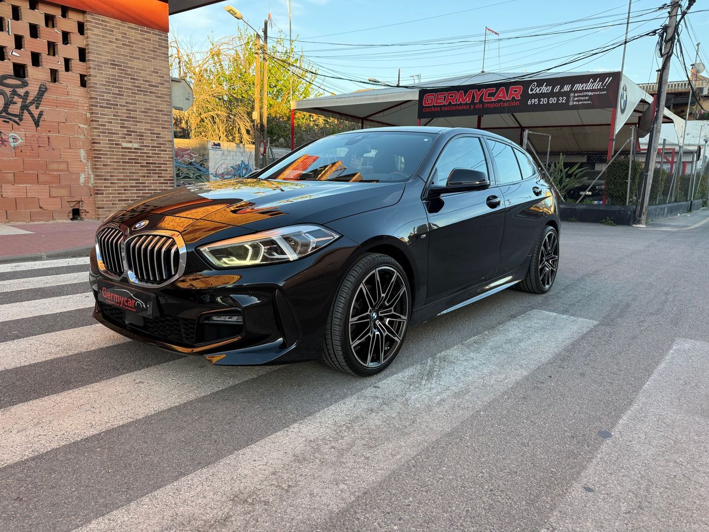 Un BMW Serie 1 hatchback de color negro en un cruce peatonal en una calle de la ciudad.