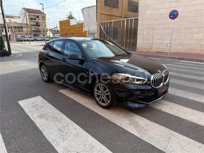 Un BMW Serie 1 hatchback de color negro en un cruce peatonal en una calle de la ciudad.