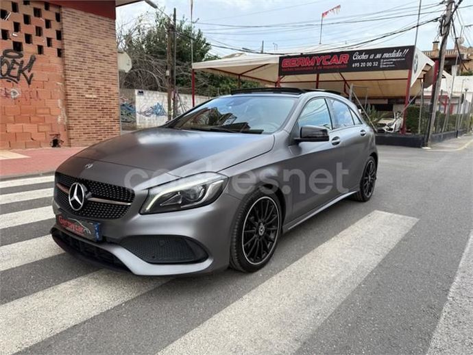 Mercedes Clase A gris estacionado en una calle cerca de un lavado de autos.