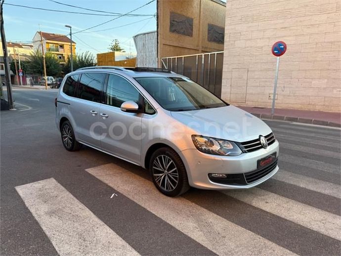 Minivan Volkswagen Sharan de color plata estacionada en un cruce peatonal en un entorno urbano.