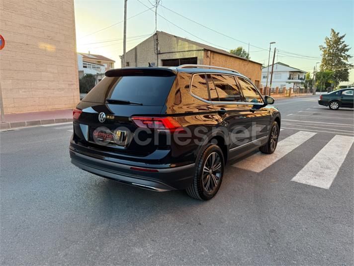 SUV Volkswagen negro estacionado en una calle cerca de un cruce de peatones.