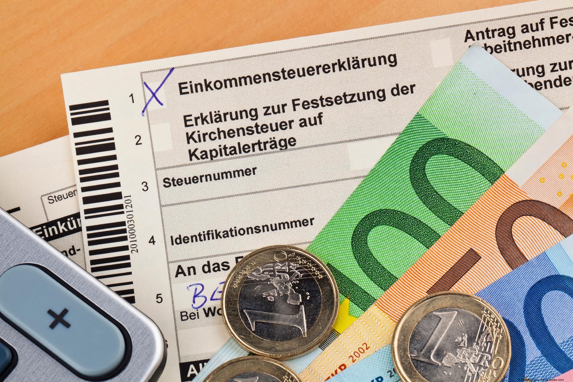 Formular zur Einkommensteuererklärung mit Euro-Geldscheinen und Münzen.