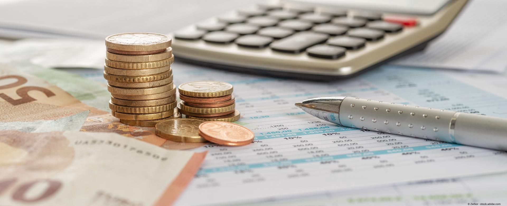 Gestapelte Münzen mit digitaler Grafik von Finanzkurven.