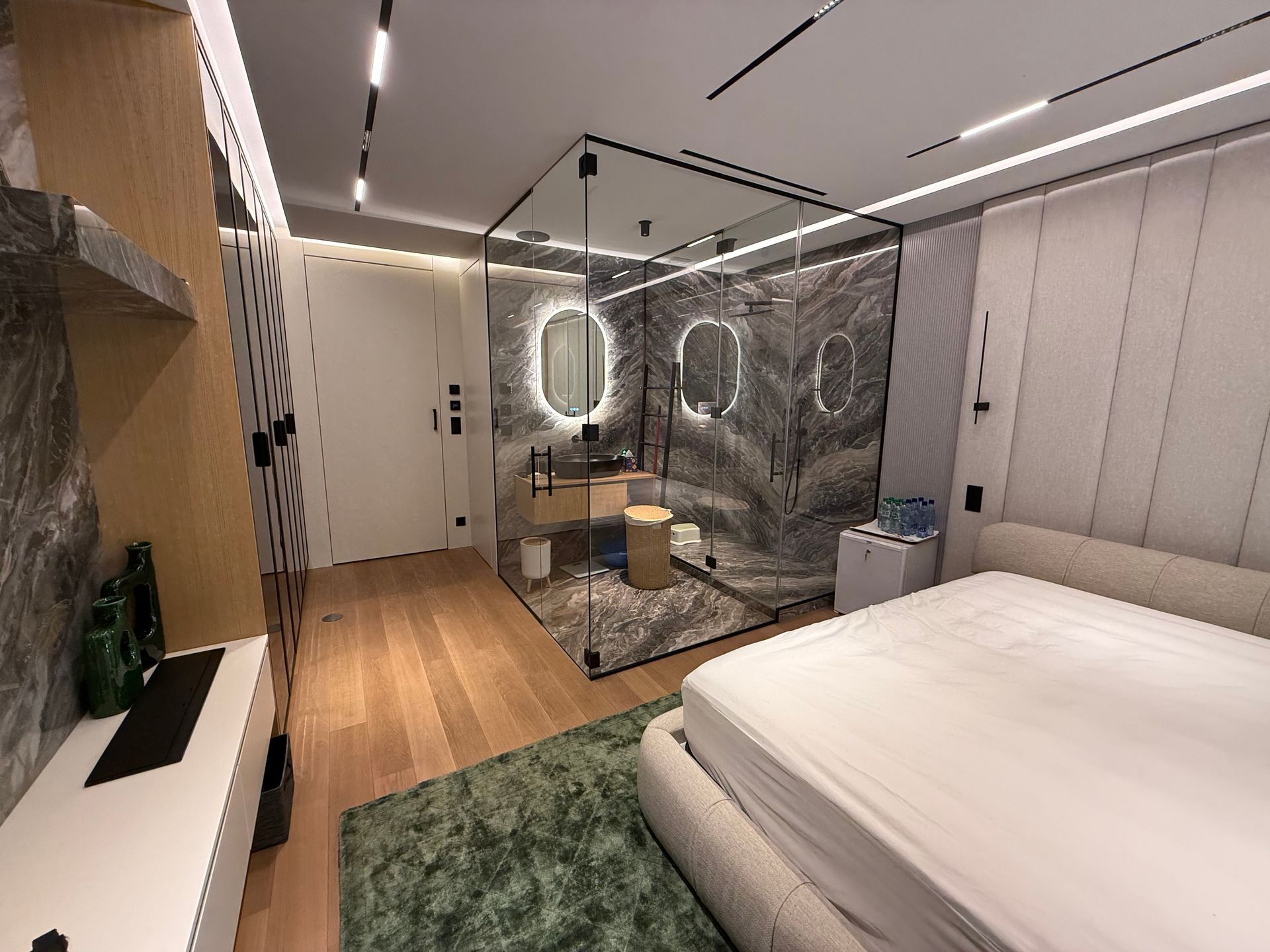 Chambre moderne avec salle de bain vitrée.