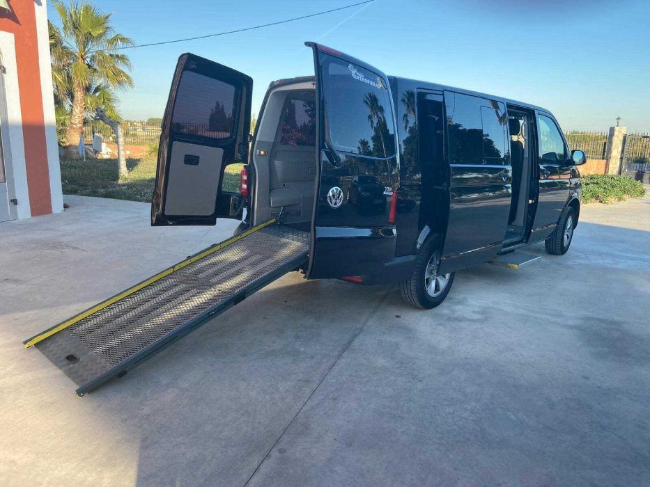 Una camioneta negra con una rampa adjunta.