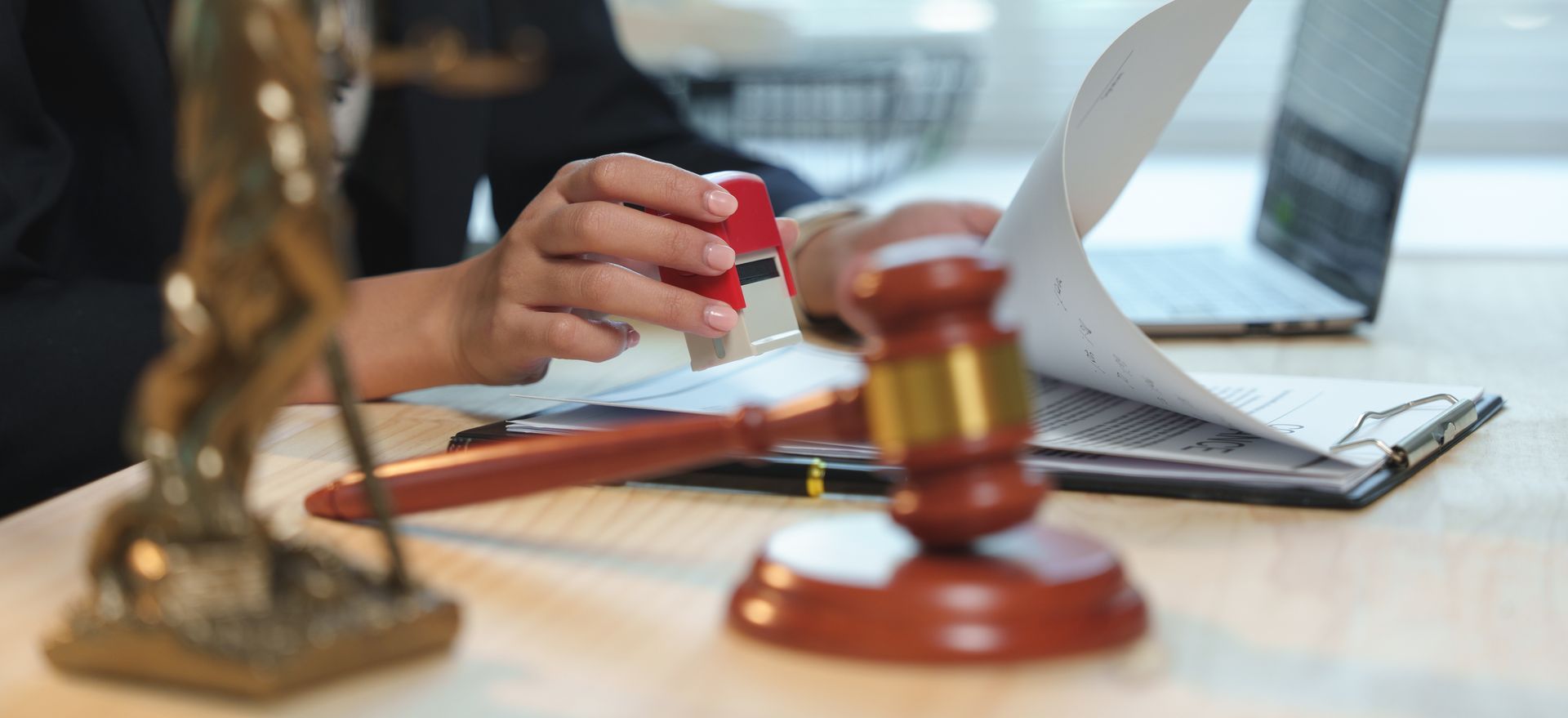 Une femme de lois apposant un tampon sur des documents juridiques.