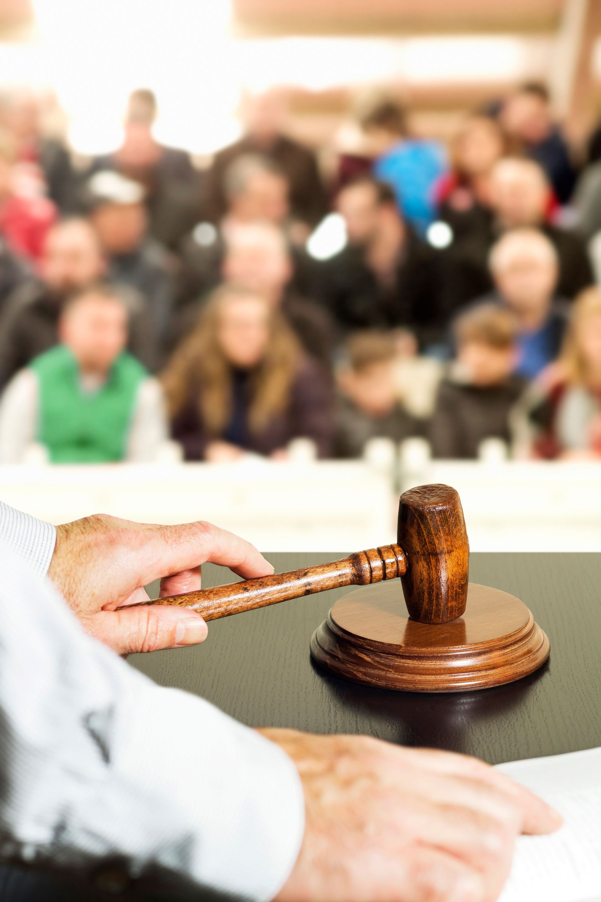 Un commissaire tenant un marteau lors d'une vente aux enchères publique.