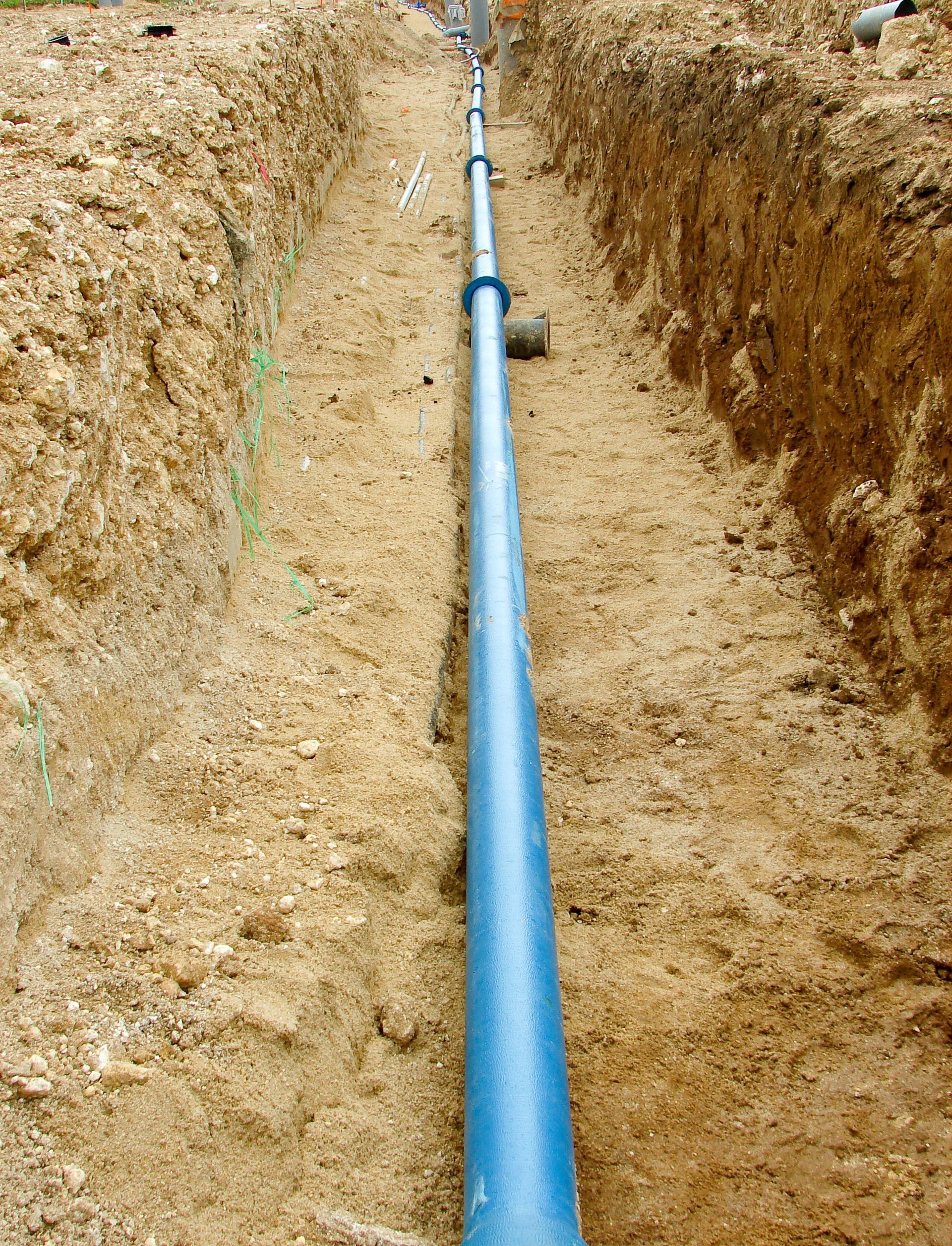 Tuyaux de raccordement visibles dans une tranchée